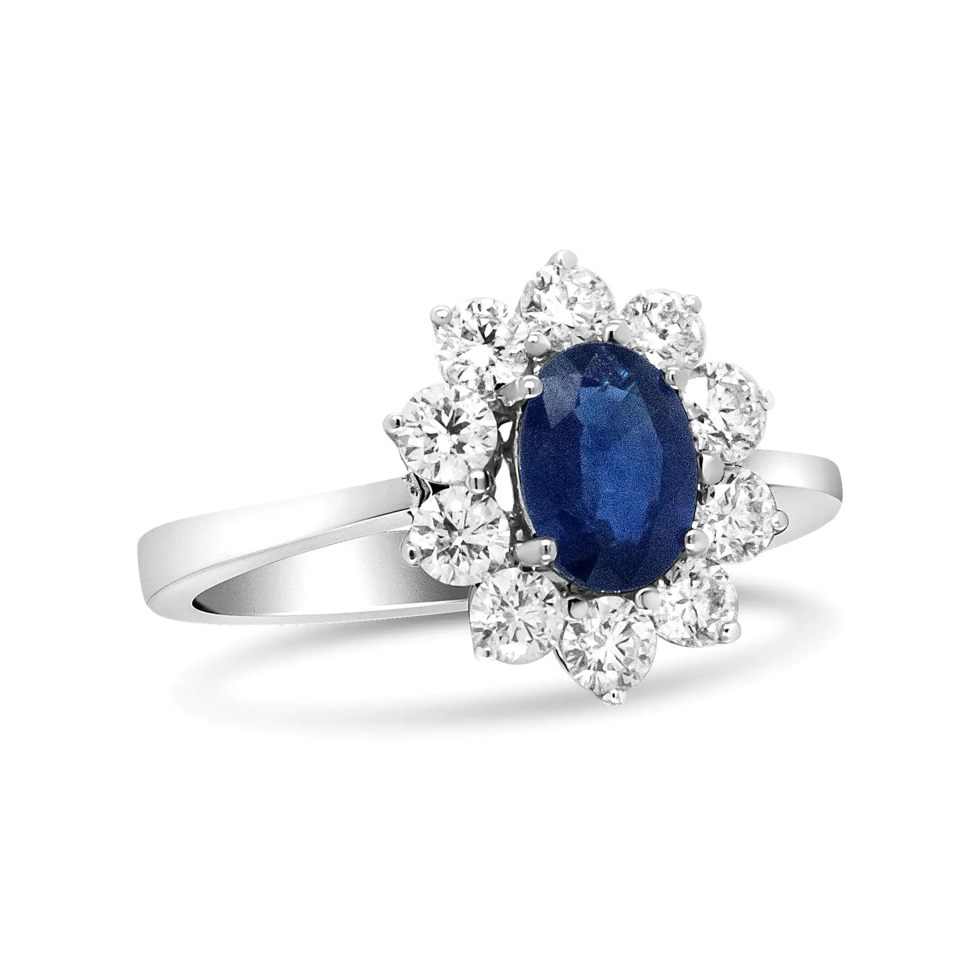 18K White Gold Oval Cut Blue Sapphire  Sunburst Halo RingA ring that mirrors that of Diane's, this 18k white gold is beautifully set with a deep blue sapphire gemstone at its center. This 7x5mm stone is flanked by a floral18K White Gold Oval Cut Blue Sapphire Sunburst Halo RingRings18K White Gold Oval Cut Blue Sapphire Sunburst Halo Ring